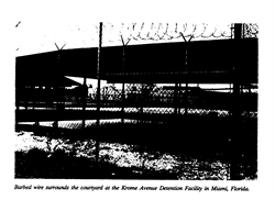 [ai] A courtyard surrounded by barbed wire at the Krome Avenue Detention Facility in Miami, Florida, with shaded structures visible above.